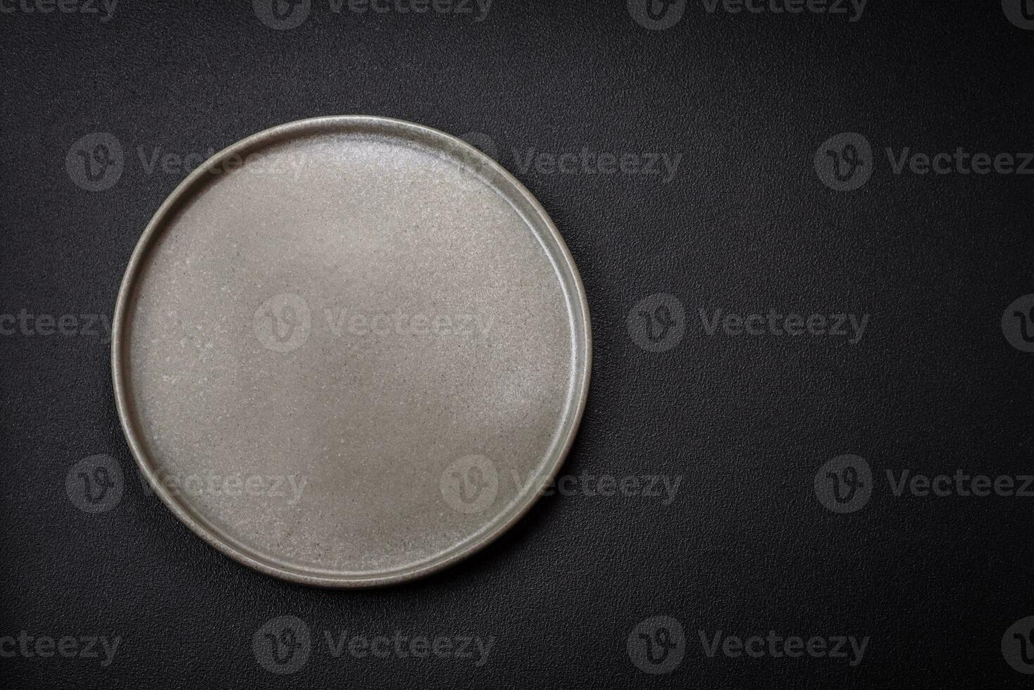 Bumpy empty ceramic plate on a textured concrete background photo