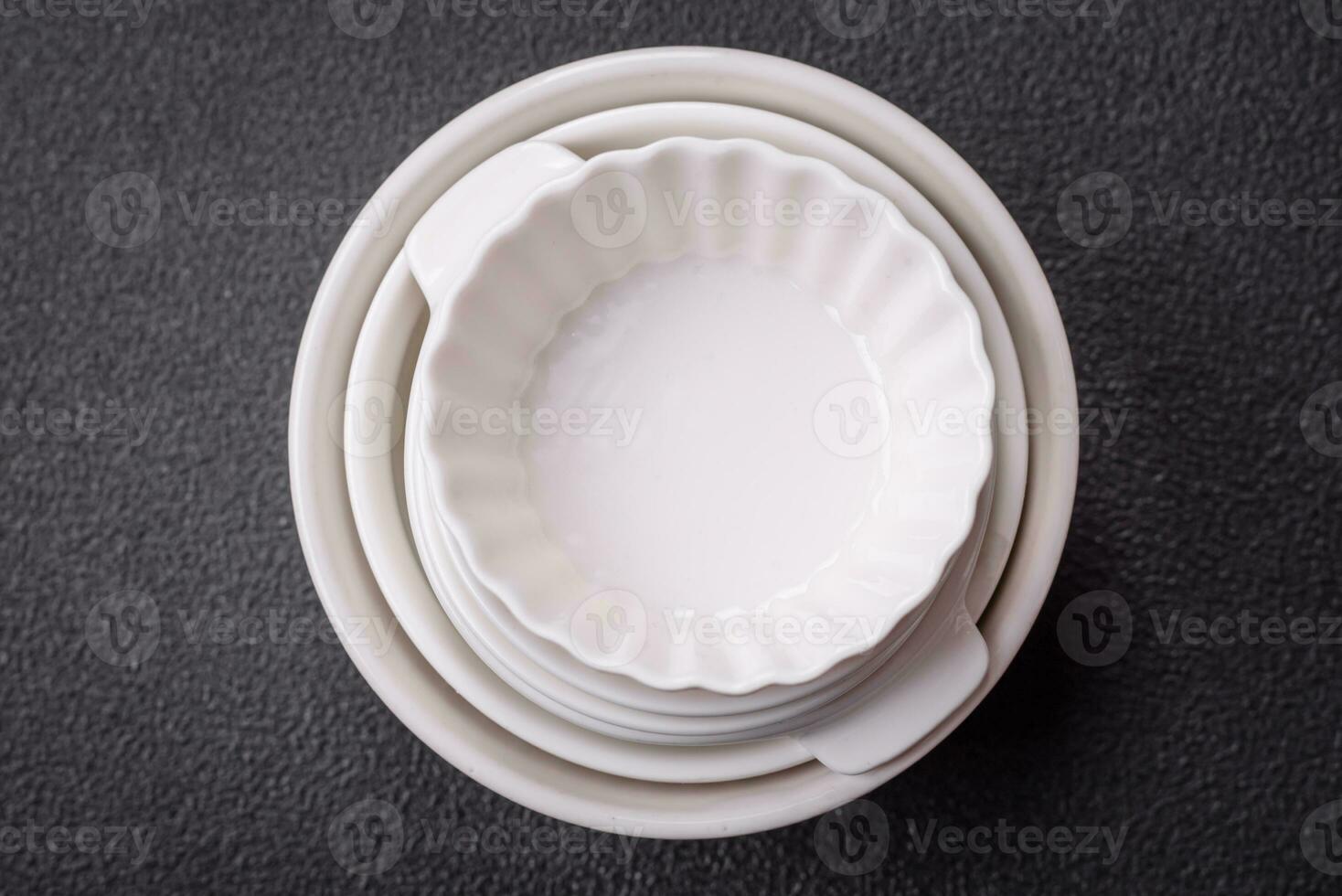 Beautiful empty white ceramic gravy boat on a textured concrete background photo