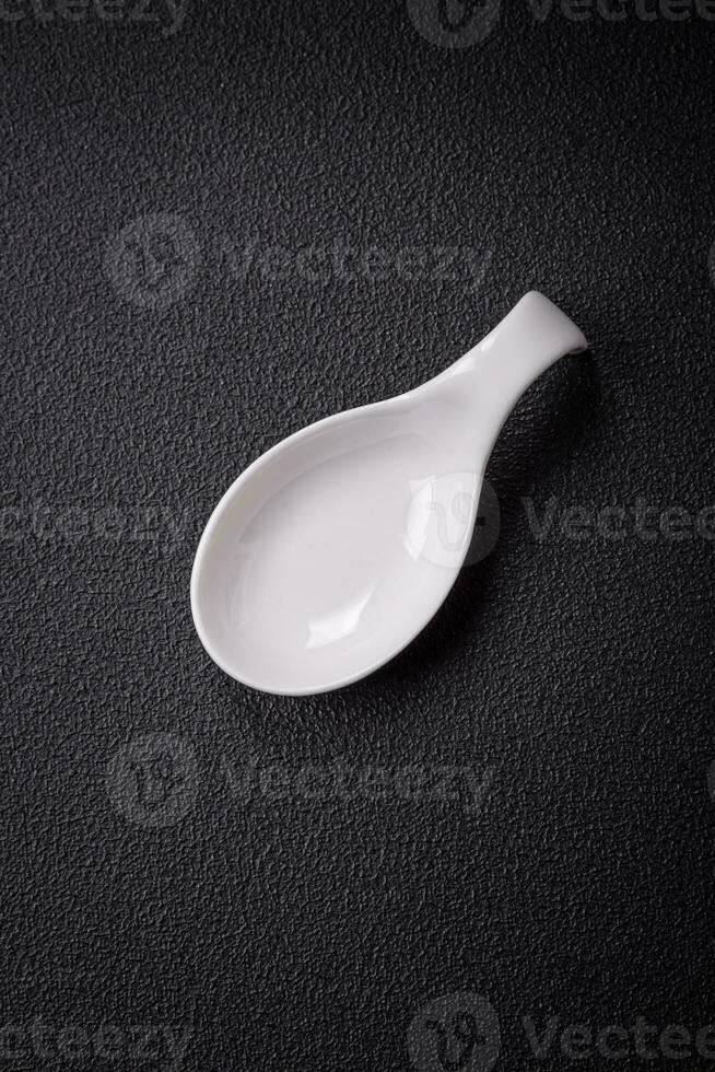 Beautiful empty white ceramic gravy boat on a textured concrete background photo