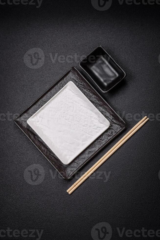 Square empty ceramic plate on textured concrete background photo