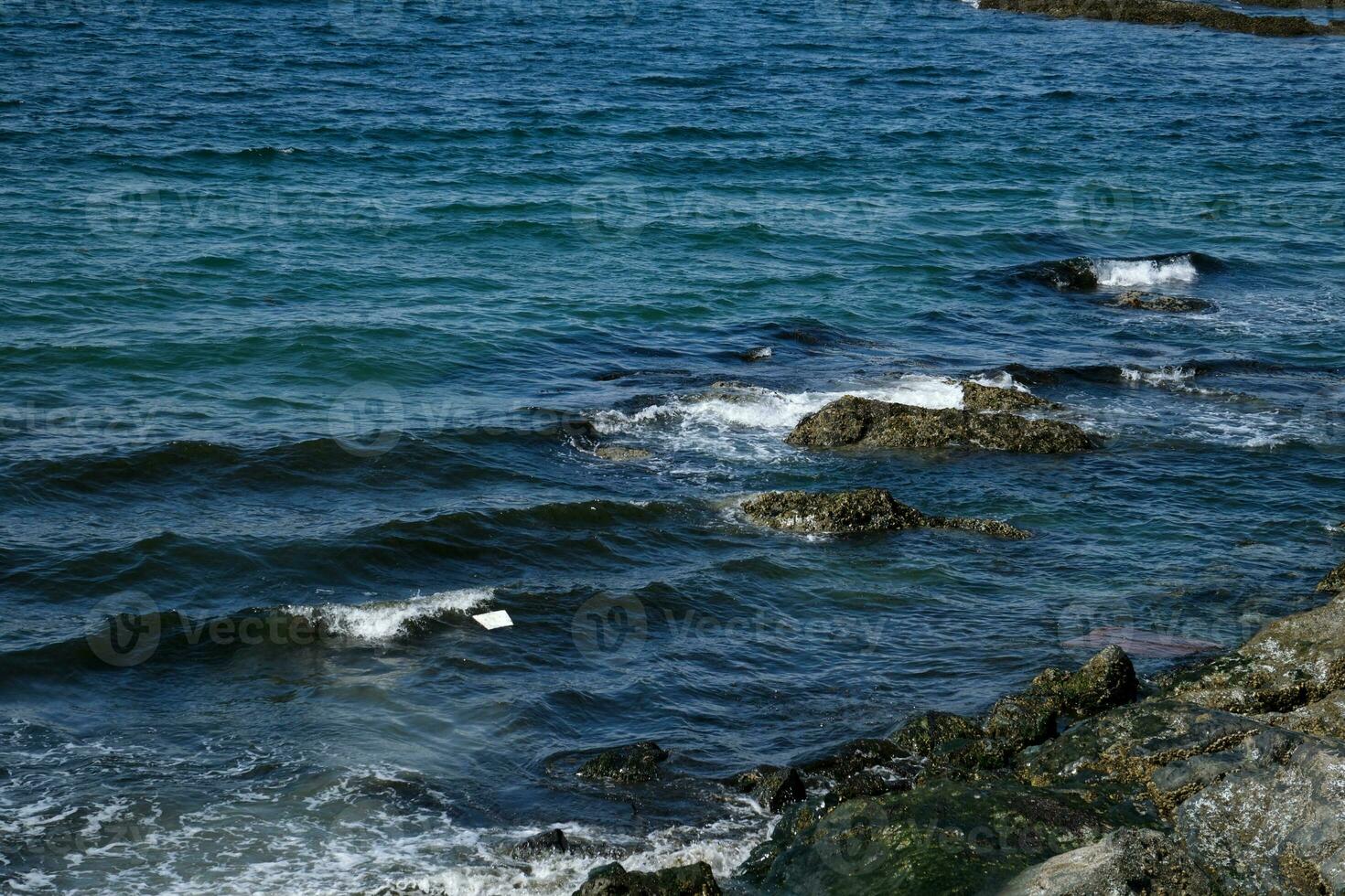 Mediterranean seascape, volcanic rocks washed out by the sea form an interesting relief in shallow water. photo