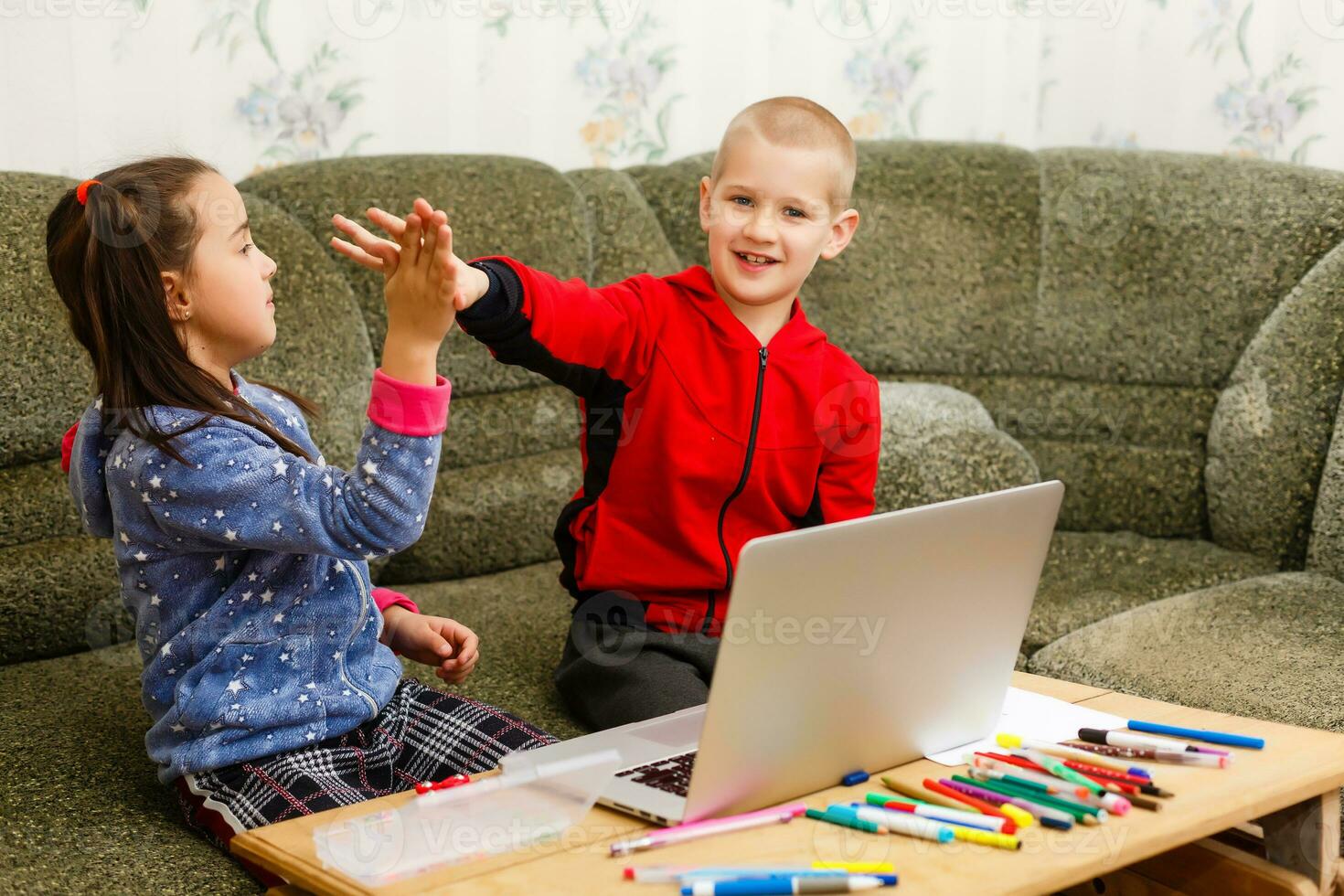Two beautiful cute happy smiling children, a boy and a girl, use laptop for distance learning or entertainment. photo