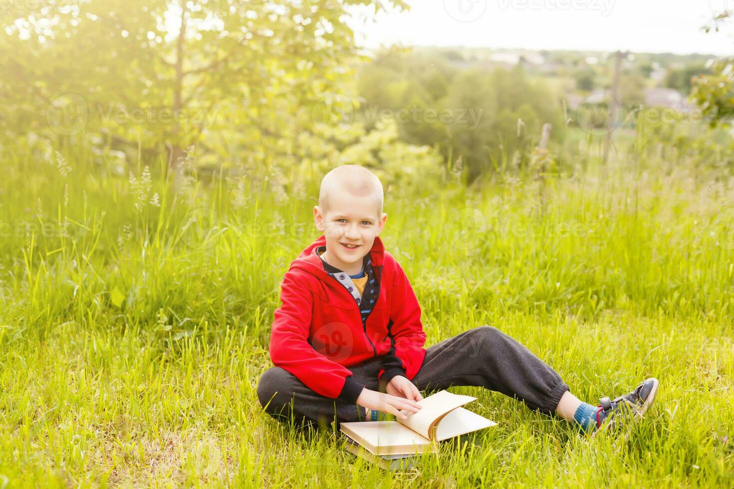 child reading a book on the grass photo