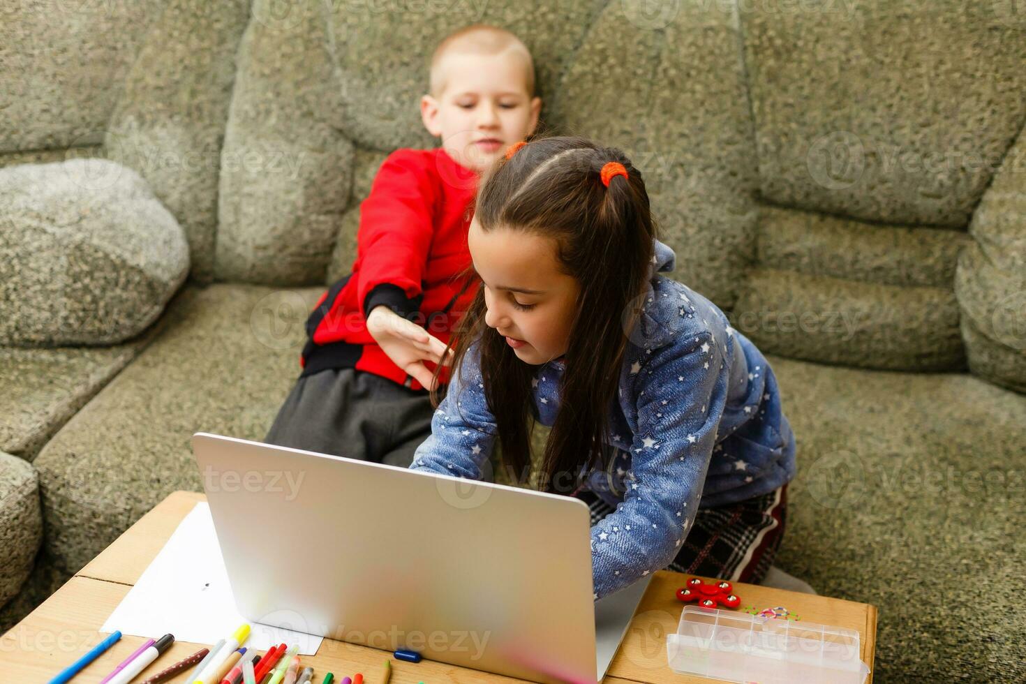 Distance learning online education. school boy and girl studying at home with laptop notebook and doing homework. Sitting at a table photo