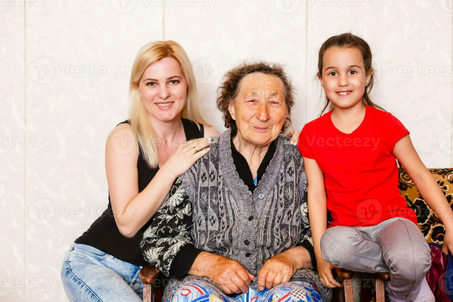 Senior woman hugging granddaughter while sitting on sofa at home photo