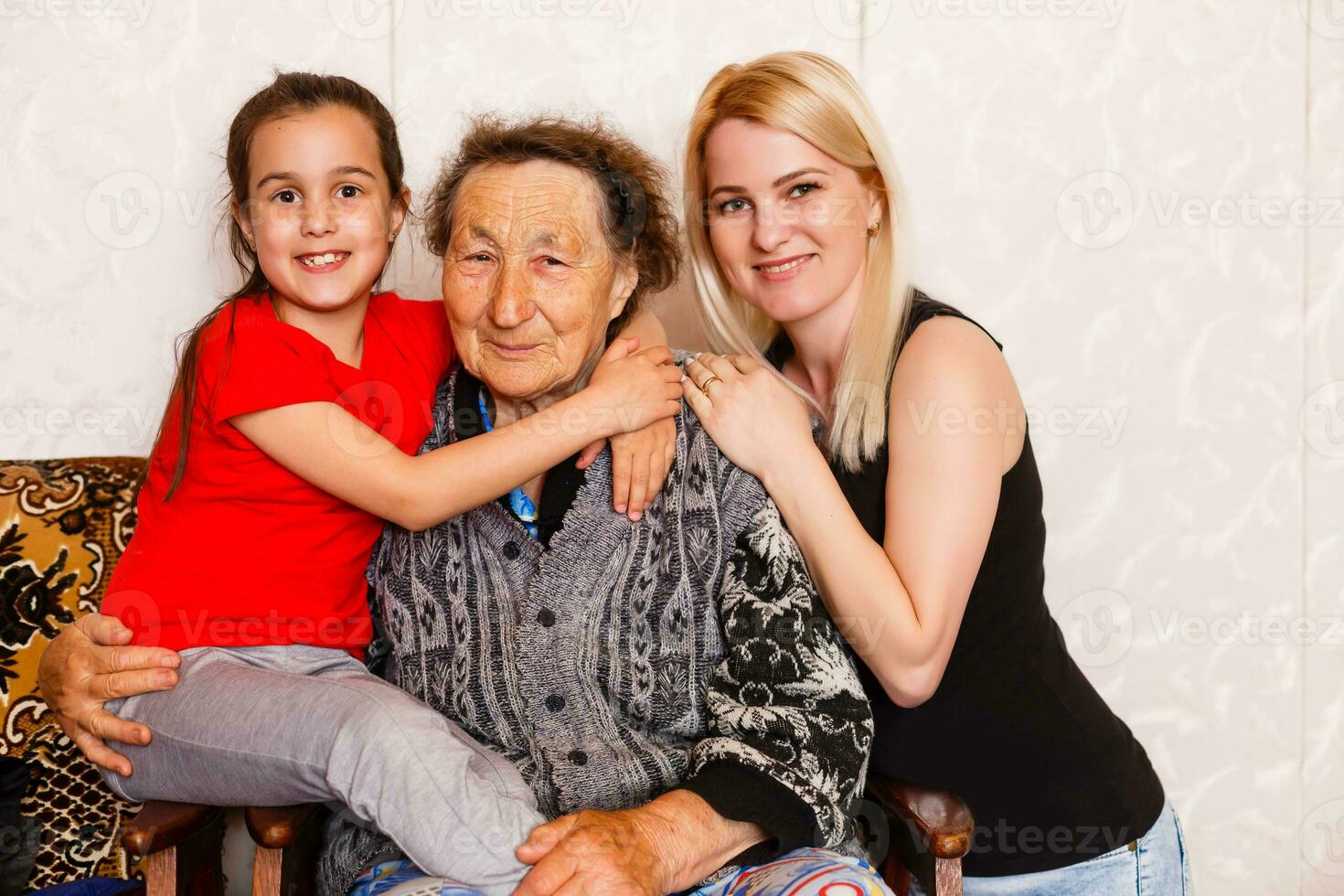 mayor mujer abrazando nieta mientras sentado en sofá a hogar foto
