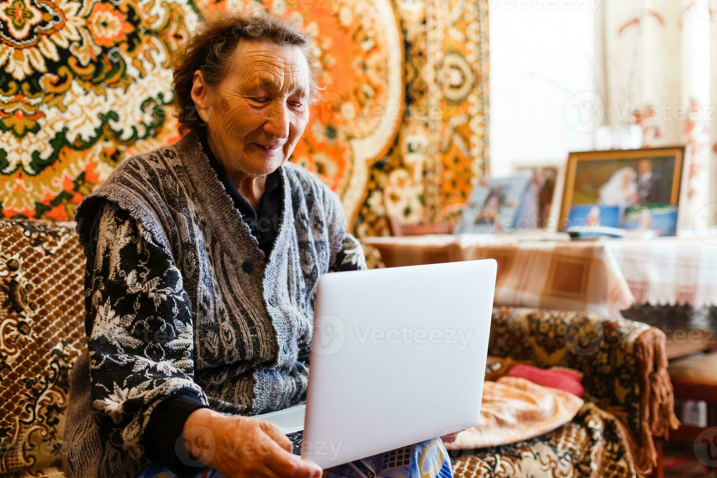 technology, old age and people concept - happy senior woman having video call at home in evening photo