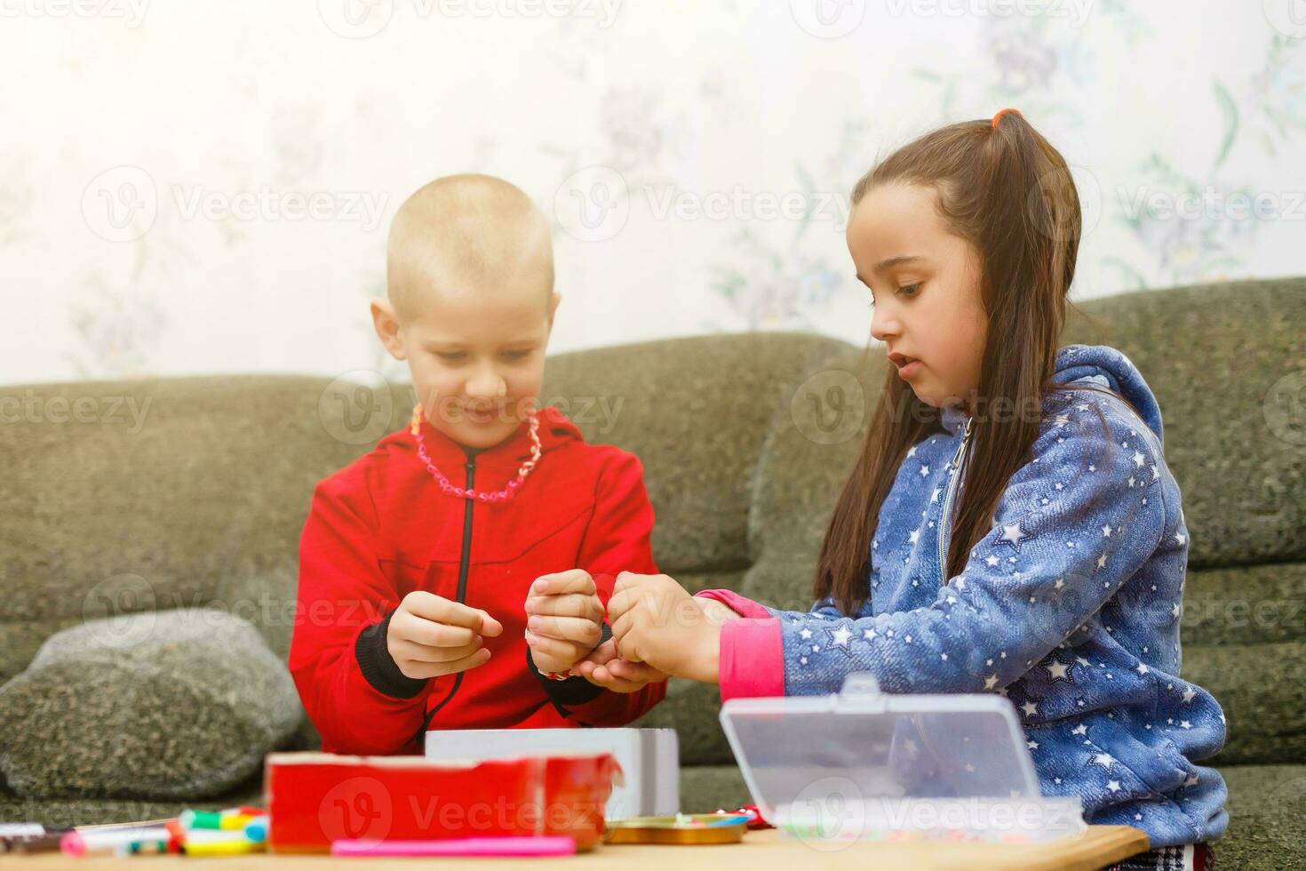 primary school children boy and girl are engaged in creative hand-made art at the table at home photo