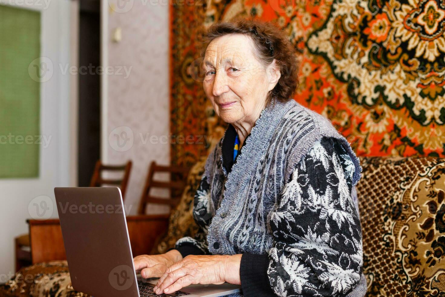 tecnología, antiguo años y personas concepto - contento mayor mujer teniendo vídeo llamada a hogar en noche foto