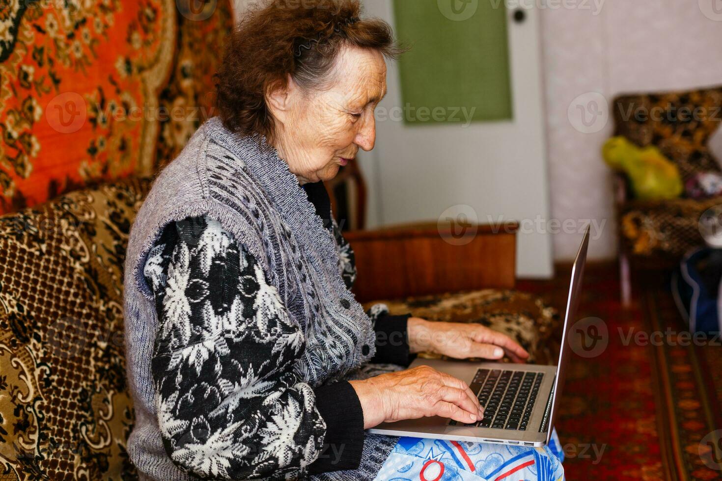 tecnología, antiguo años y personas concepto - contento mayor mujer teniendo vídeo llamada a hogar en noche foto