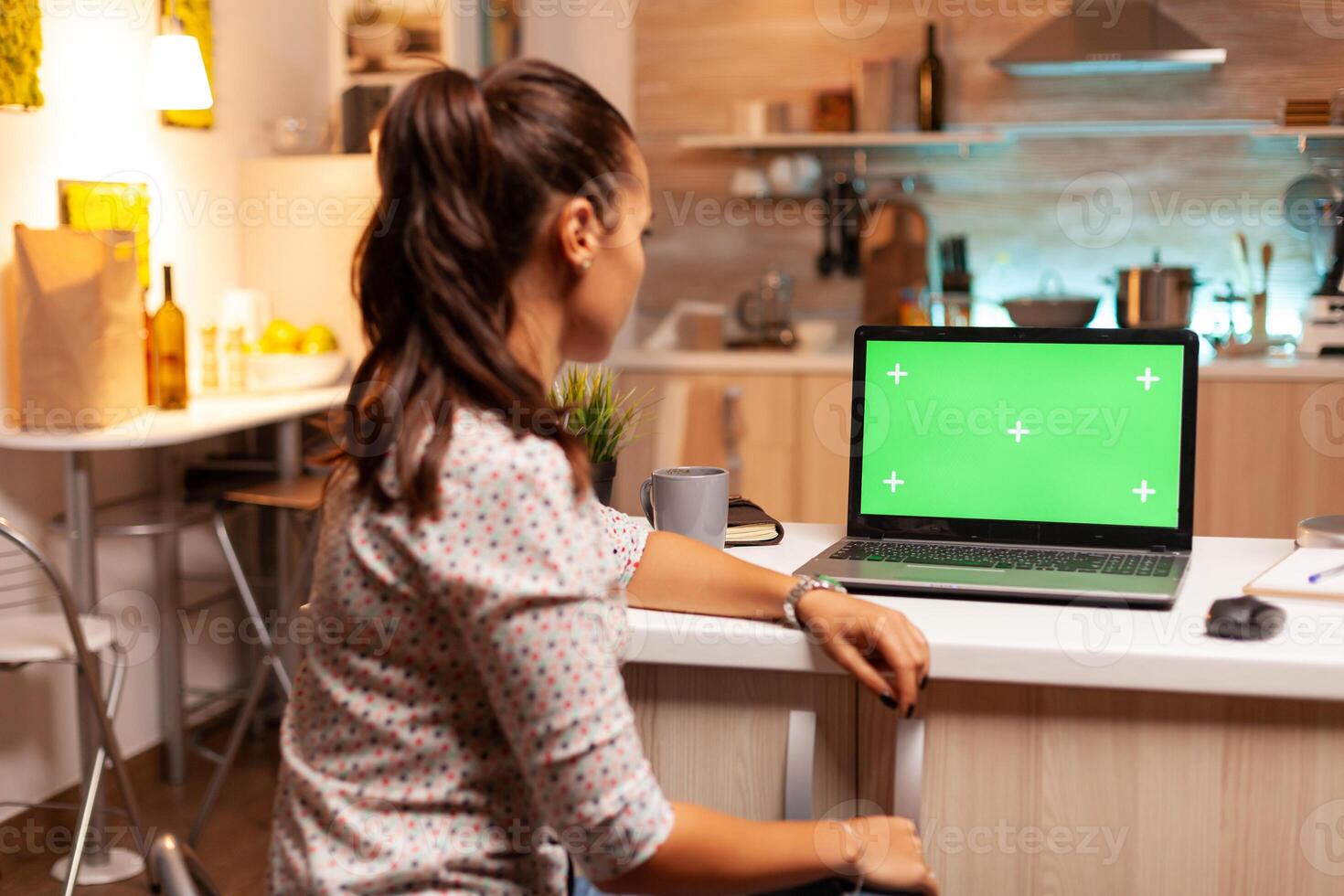 Woman using laptop with green mockup. Sitting at desk works on computer late at night, business, online, smart, blank, copyspace, digital, display. photo