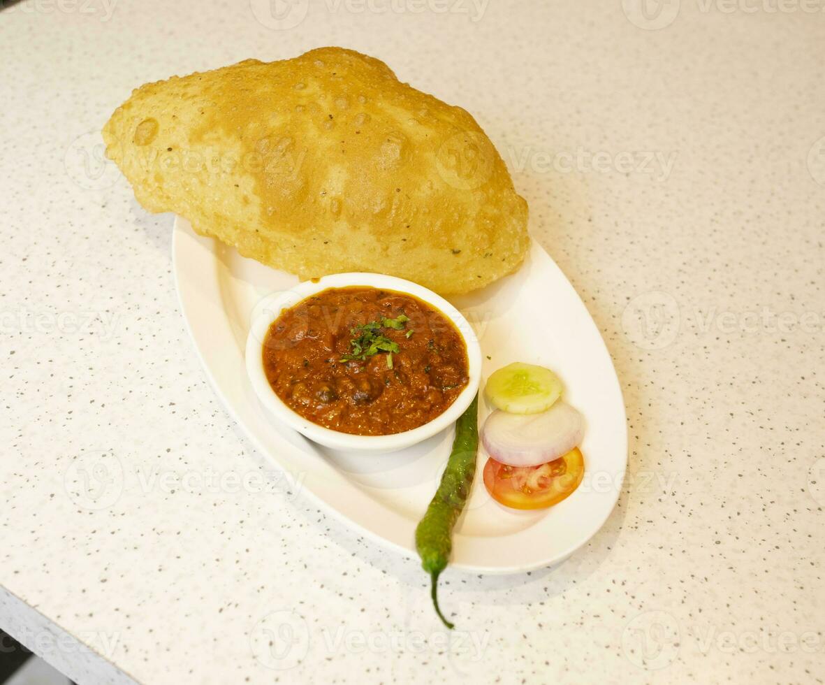 Indian Cuisine Chole Bhature Also Know as Chick Pea Curry, Chole Bhture or Chola, Chana Masala Served With Fried Puri is a Dish From The Punjab photo