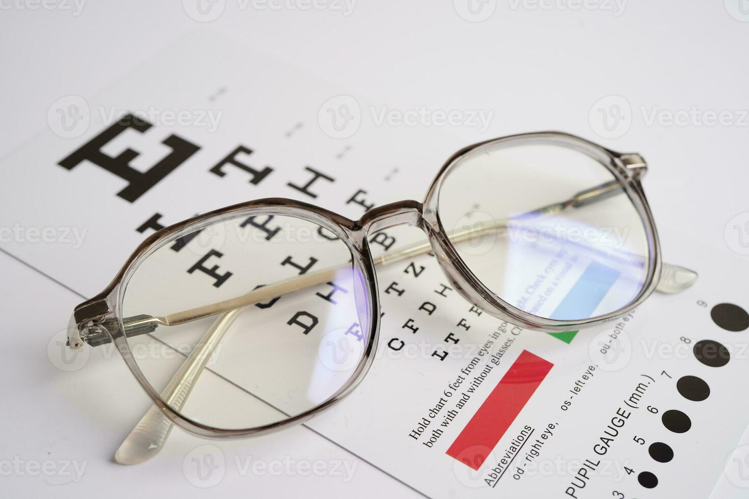 Glasses on eye exam chart to test eyesight accuracy of reading. photo