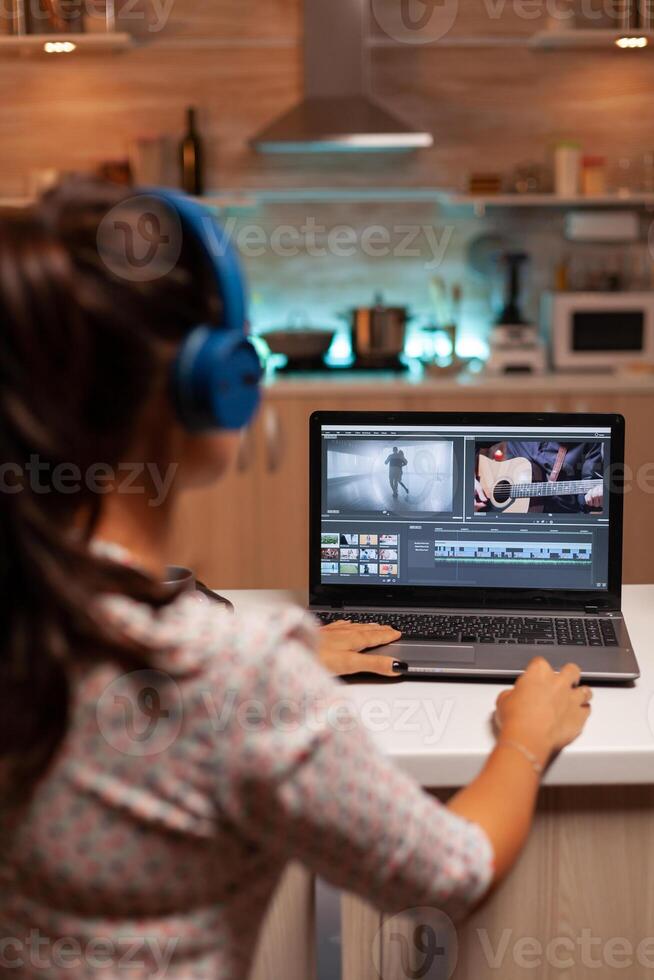 Movie maker editing a film using modern software for post production. Content creator in home working on montage of film using modern software for editing late at night. photo