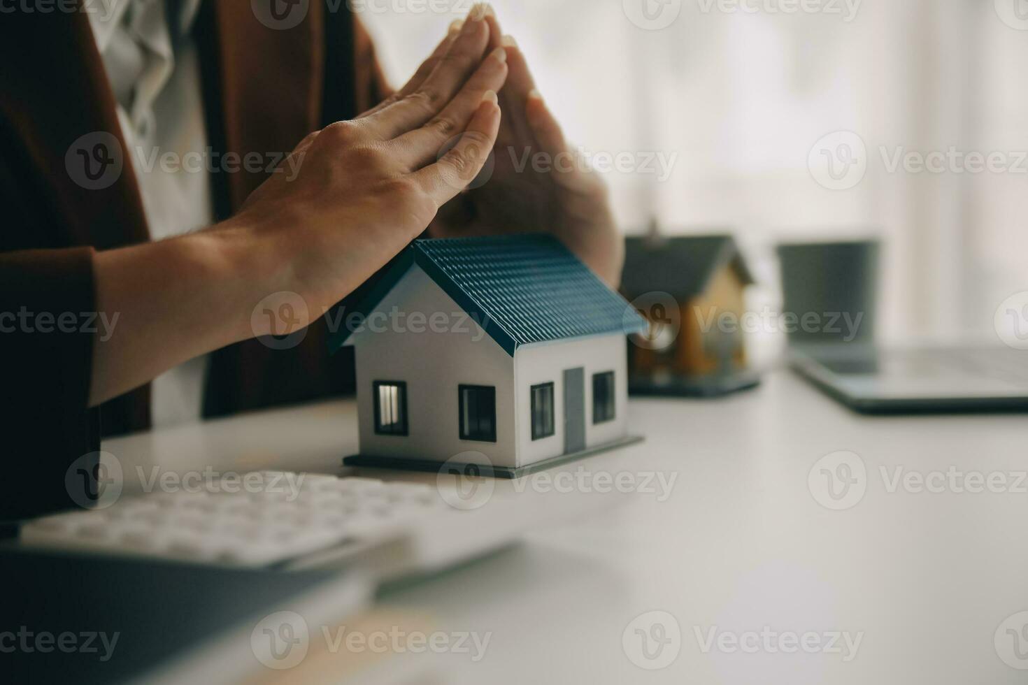 Real estate broker agent presenting and consult to customer to decision making sign insurance form agreement, buy and sell home model, concerning mortgage loan offer for and house insurance photo