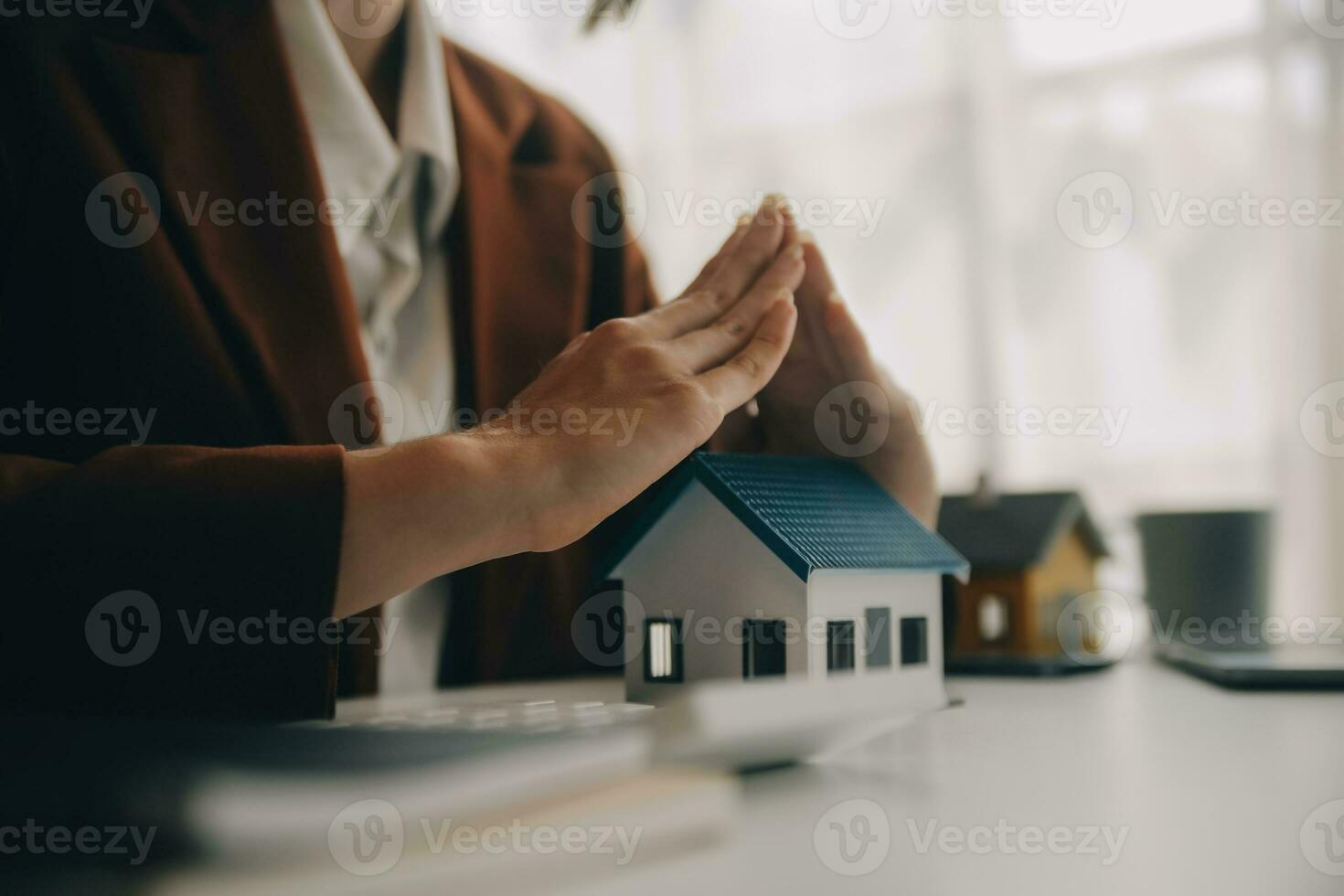 Real estate broker agent presenting and consult to customer to decision making sign insurance form agreement, buy and sell home model, concerning mortgage loan offer for and house insurance photo