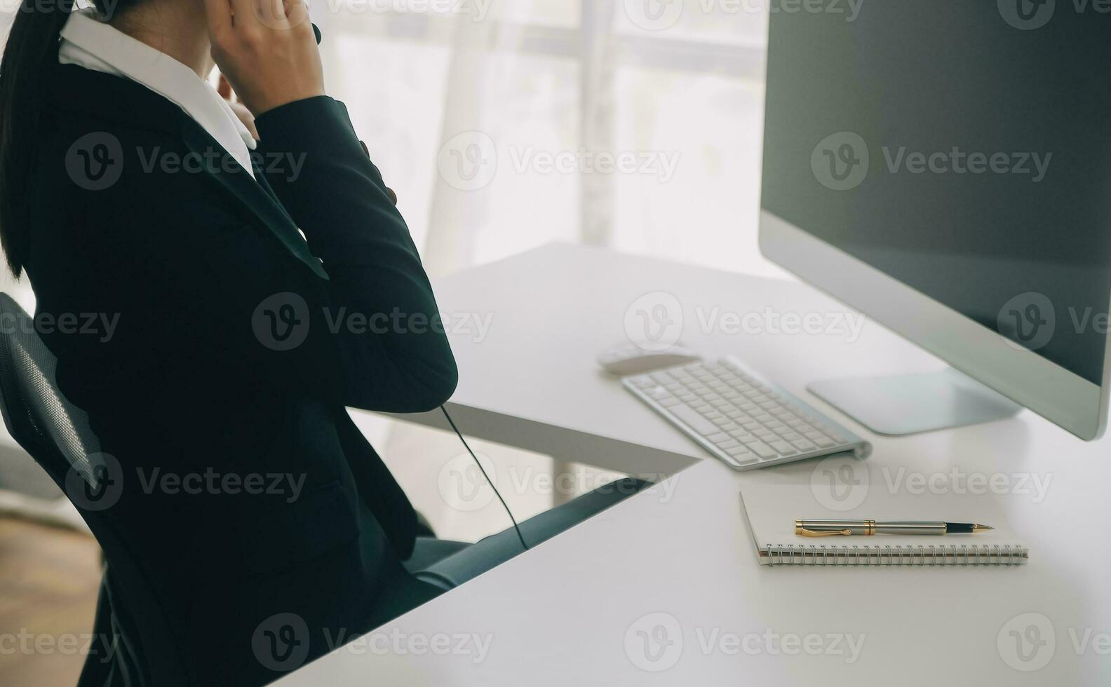 Beautiful female call center operator working on computer in office photo