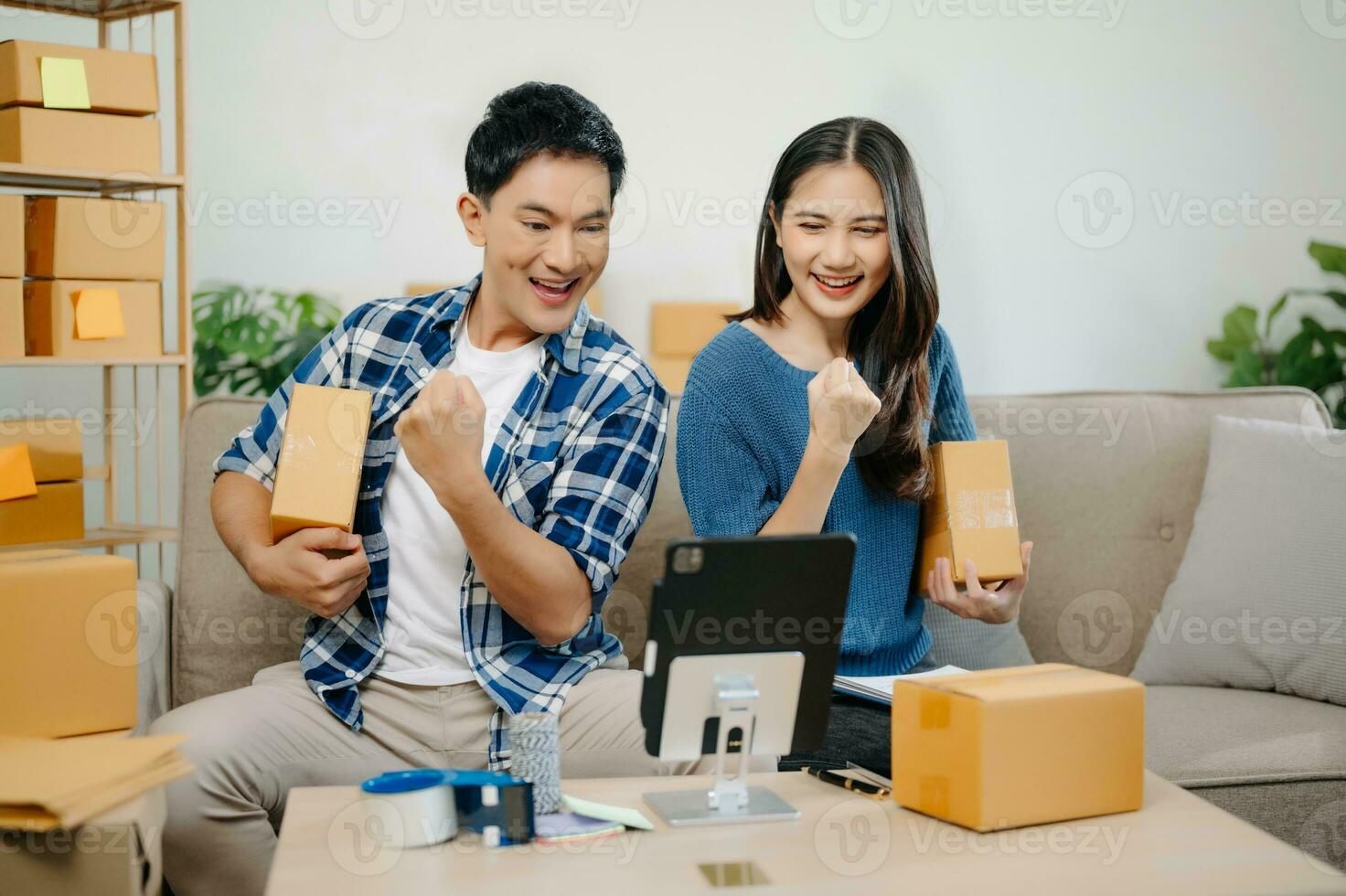 Two Asian blogger showing clothes in front of the camera to recording vlog video live streaming at her shop. photo