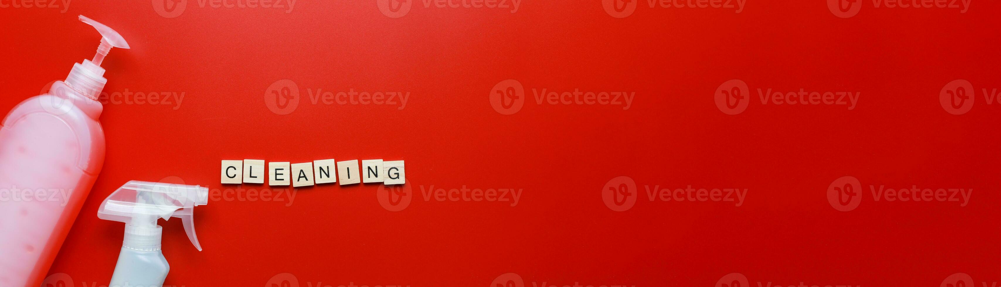 Banner Flat lay cleaning products and sponges on a red background. Word cleaning from letters. Cleaning Spray Mockup photo