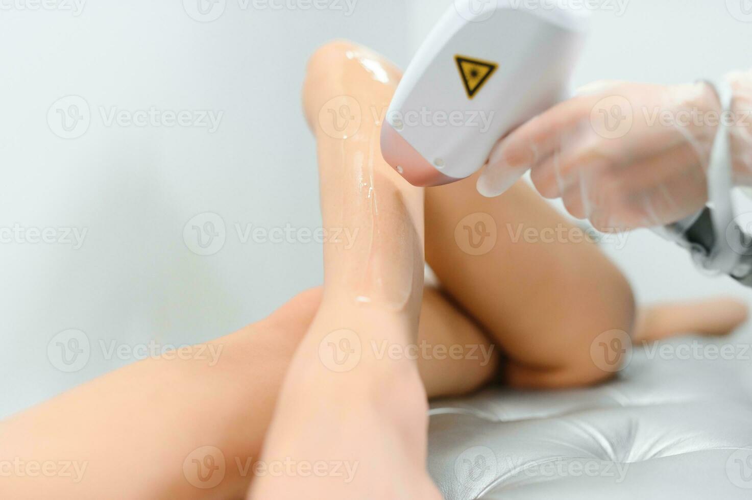 close-up of young caucasian slender woman getting laser epilation in beauty salon. photo