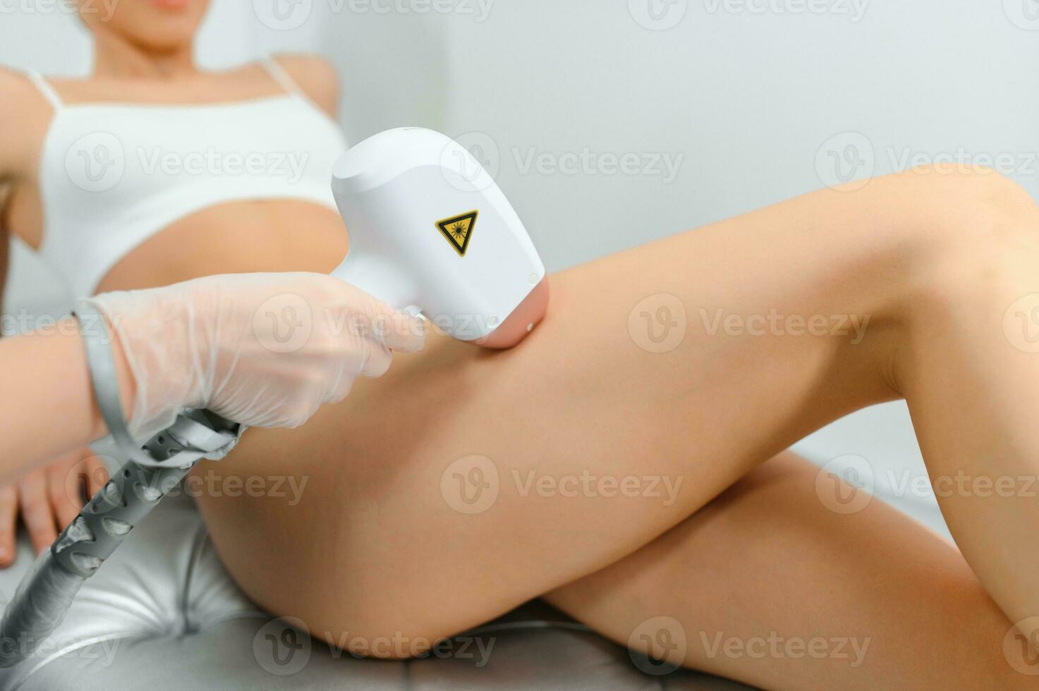 close-up of young caucasian slender woman getting laser epilation in beauty salon. photo