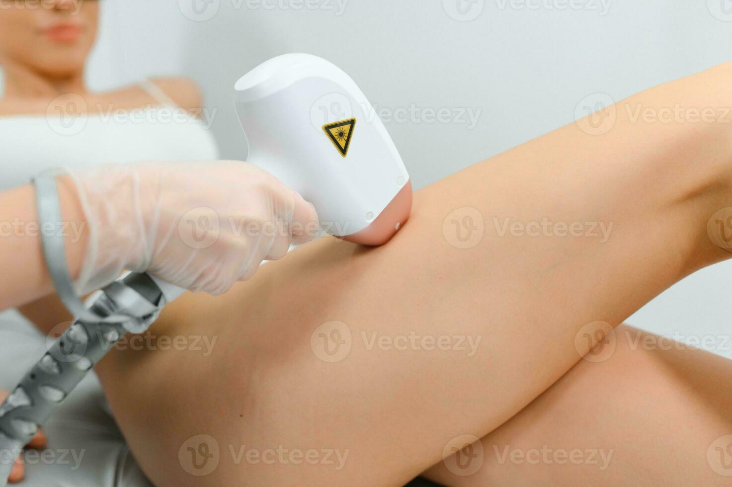 close-up of young caucasian slender woman getting laser epilation in beauty salon. photo