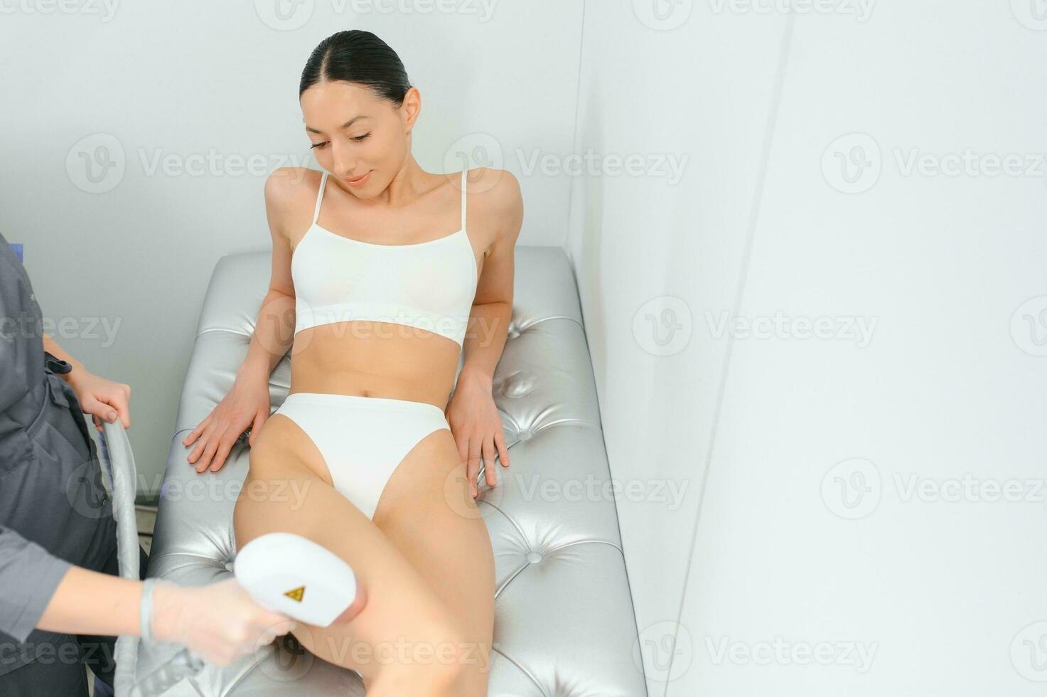 close-up of young caucasian slender woman getting laser epilation in beauty salon. photo