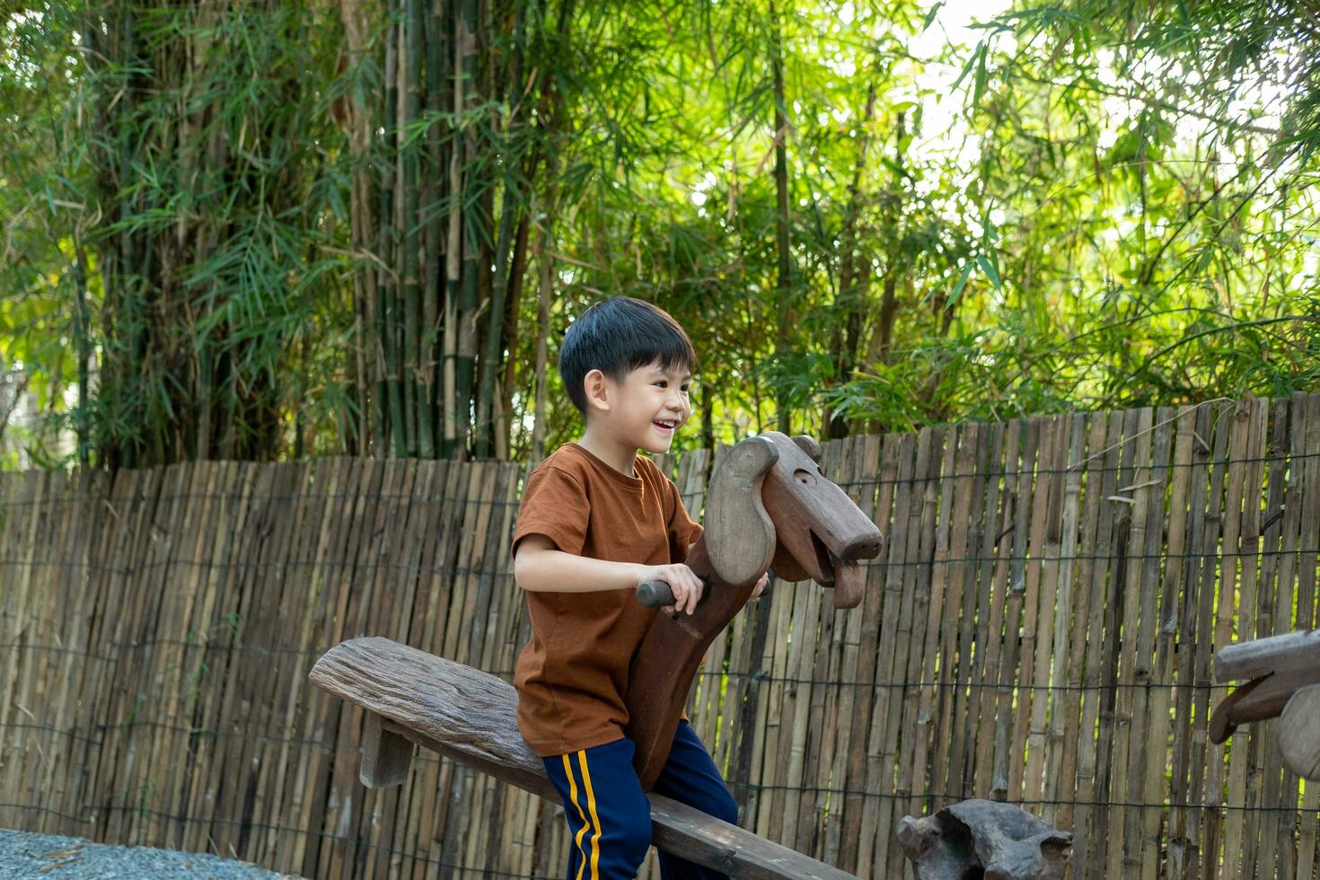 Little Asian boy playing children's sports equipment outdoors photo