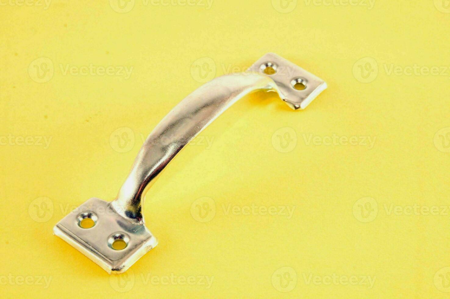 a close up of a metal handle on a yellow background photo