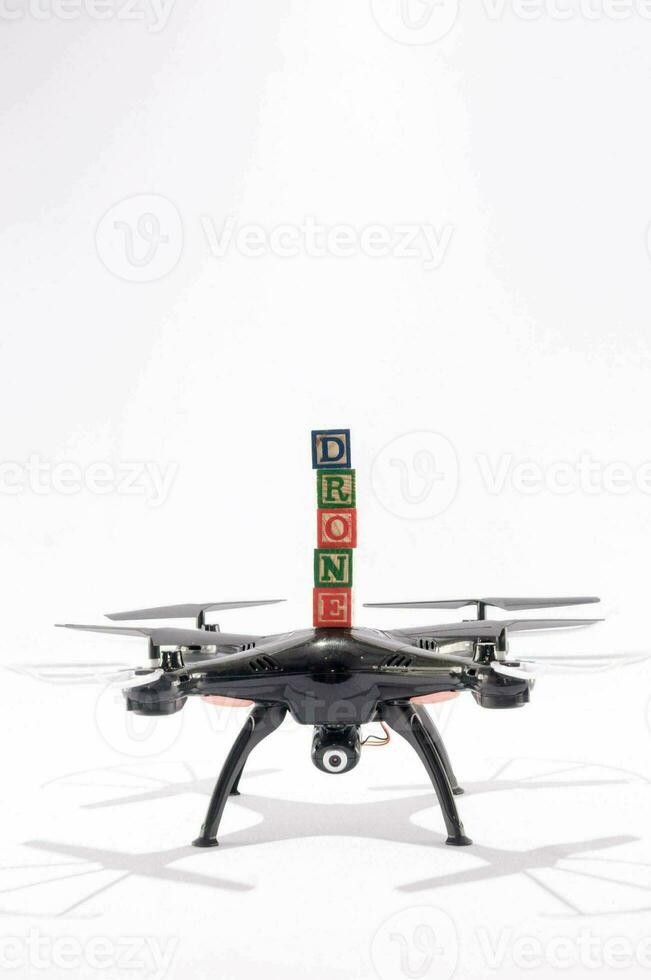 a black drone with toy blocks spelling drone on top photo