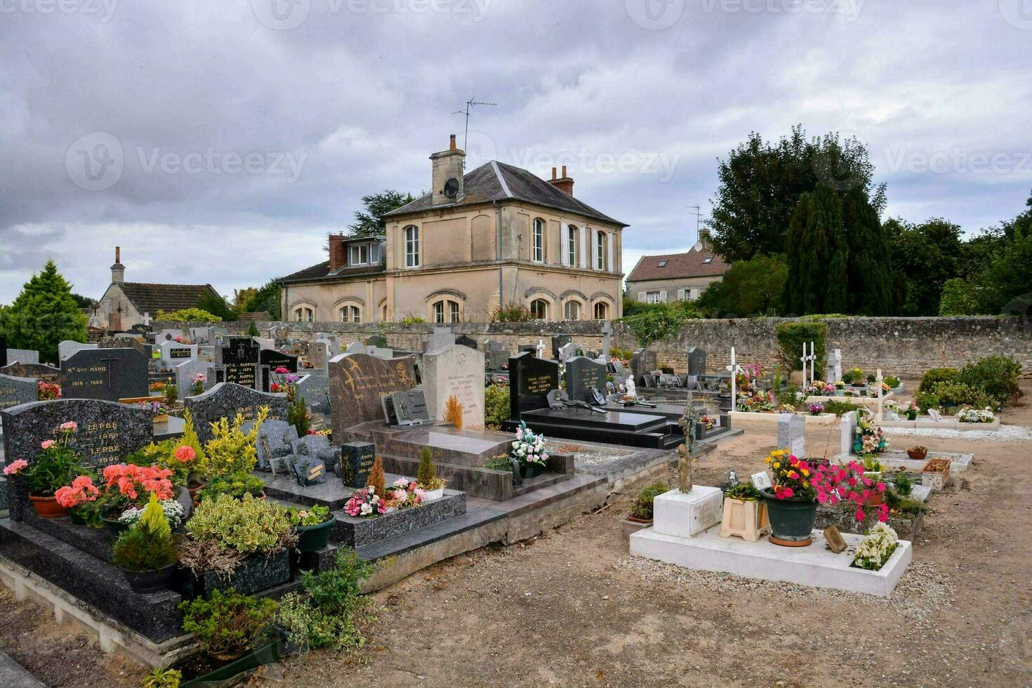 a cemetery with many graves and flowers in front of a house photo