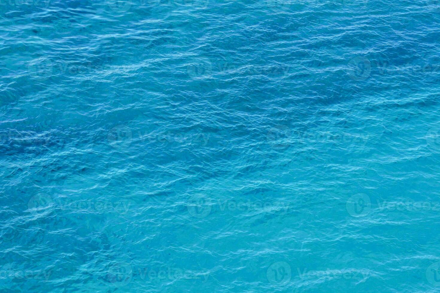 an aerial view of the ocean with blue water photo