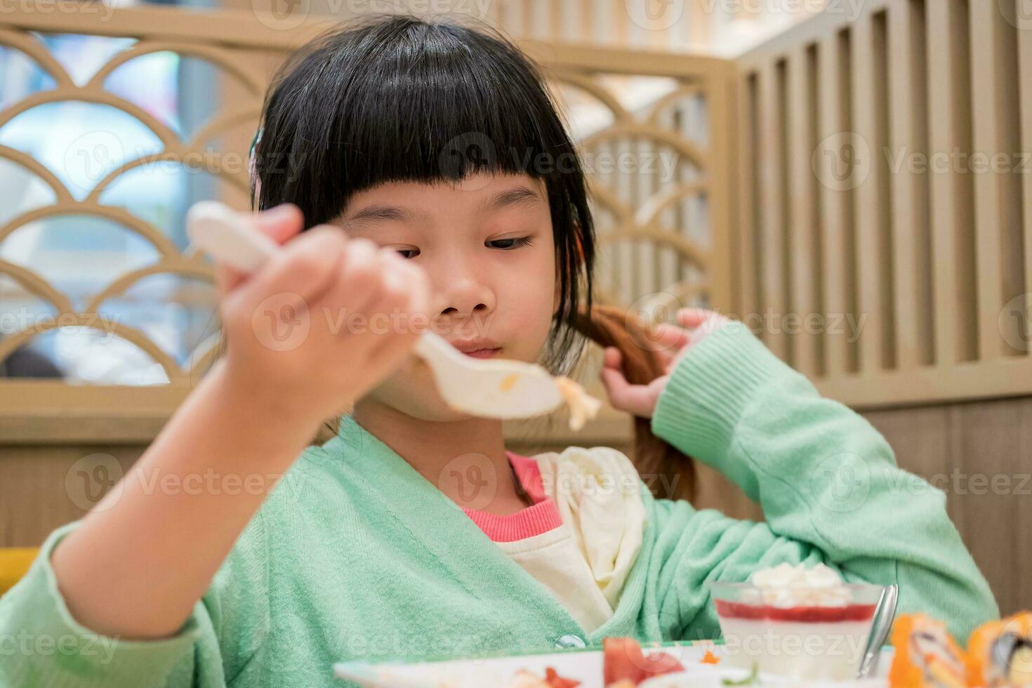 linda pequeño asiático niño niña comiendo comida foto