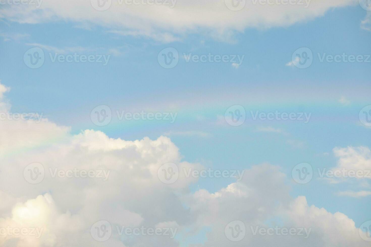 Beautiful rainbow with clouds and blue sky photo