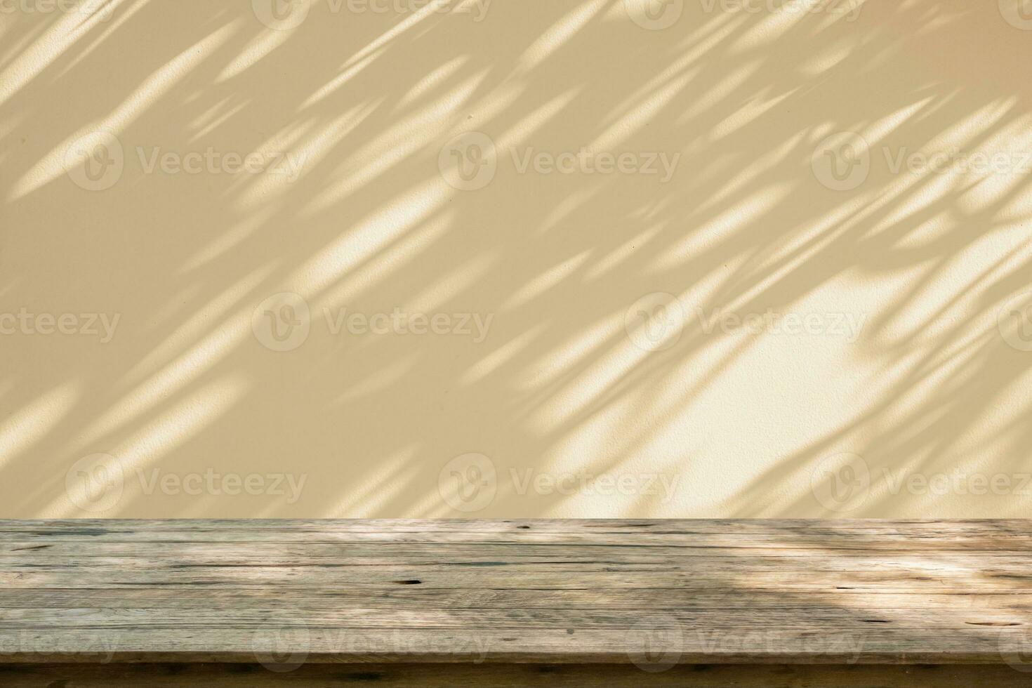 vacío madera mesa parte superior en beige pared textura con árbol hojas sombra antecedentes foto