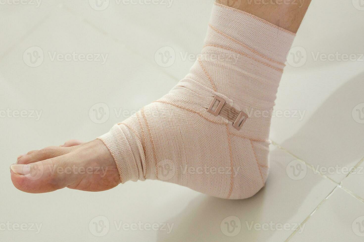 Man with ankle sprain elastic bandage for ankle injury and feeling pain photo