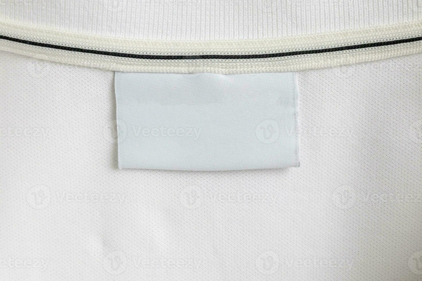 Blank white laundry care clothes label on white shirt fabric texture background photo