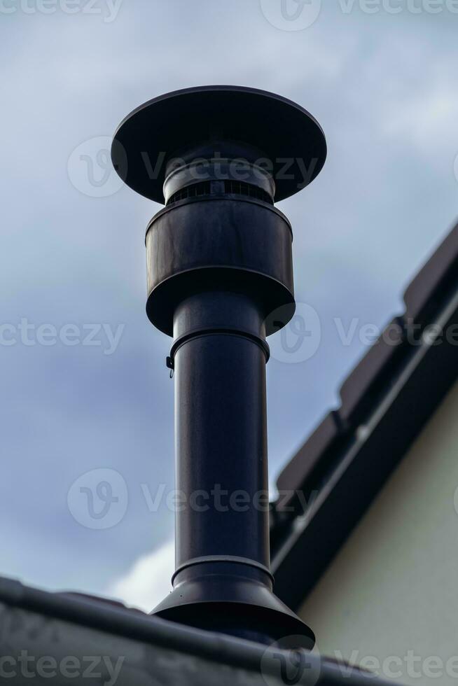 Chimney of a wood or pellet stove installed on the roof photo