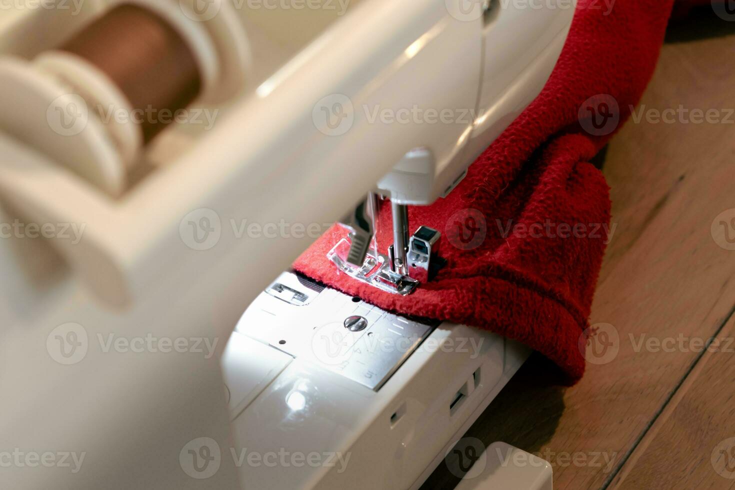 Man using a sewing machine with a red garment, for repair work