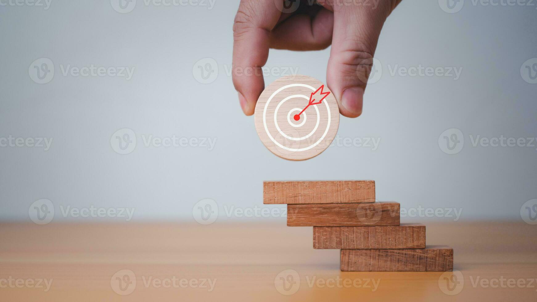 Businessman's hands hold a circular wooden board with a dartboard. It represents the concept of business strategy and target action plan. photo