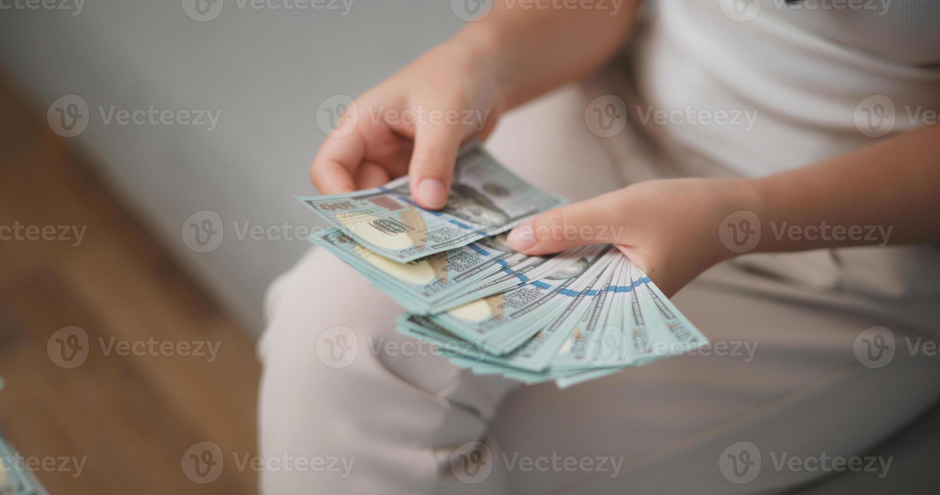 Portrait close up of young asian woman counts cash dollar bills while sitting in living room at home,counting stack cash money dollar, Financial planning. photo