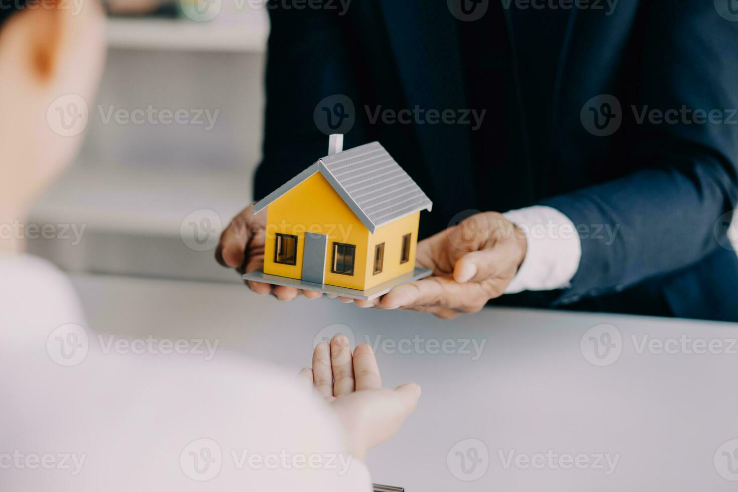 A couple is approaching a housing project to buy, and they are discussing details and advice with a salesperson in a housing project. Real estate trading ideas with couples. photo