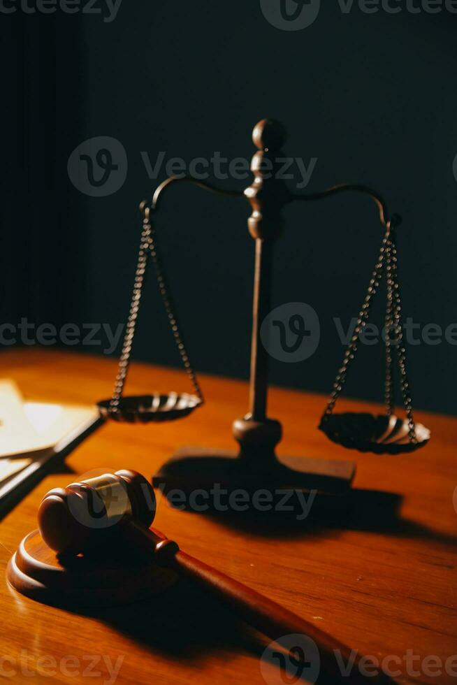 Business and lawyers discussing contract papers with brass scale on desk in office. Law, legal services, advice, justice and law concept picture with film grain effect photo
