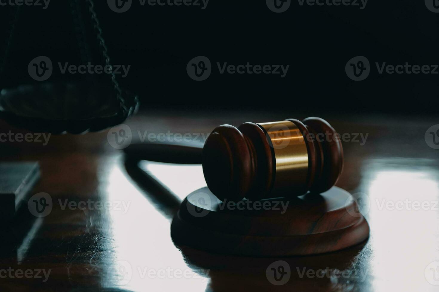 Justice and law concept.Male judge in a courtroom with the gavel, working with, computer and docking keyboard, eyeglasses, on table in morning light photo