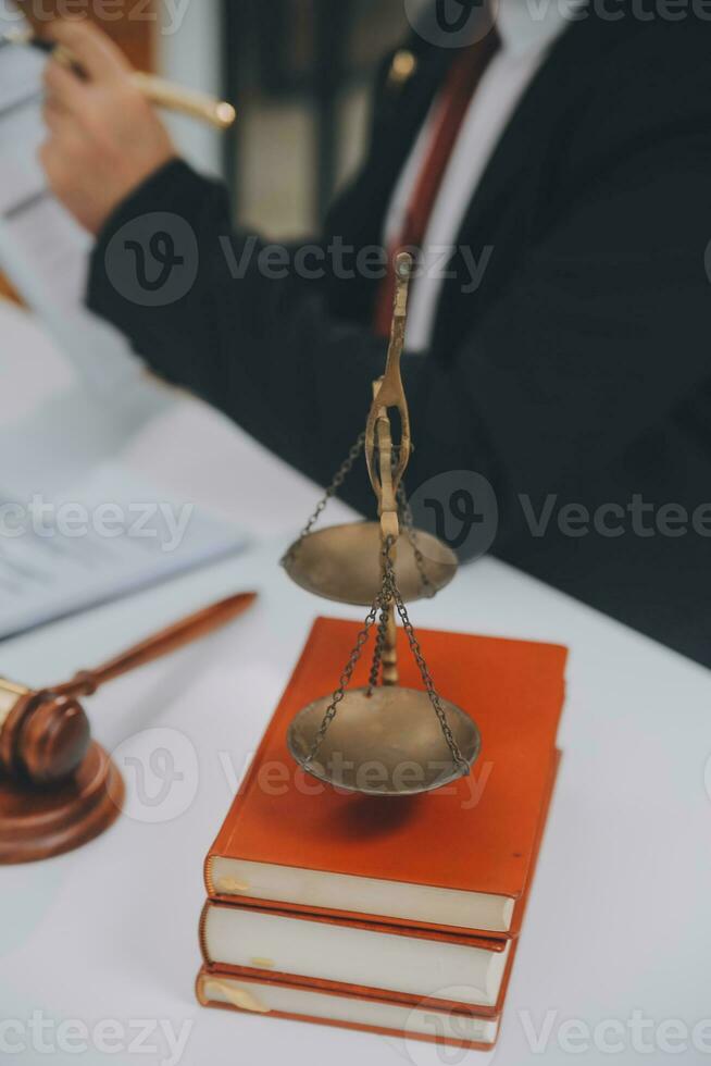 Business and lawyers discussing contract papers with brass scale on desk in office. Law, legal services, advice, justice and law concept picture with film grain effect photo