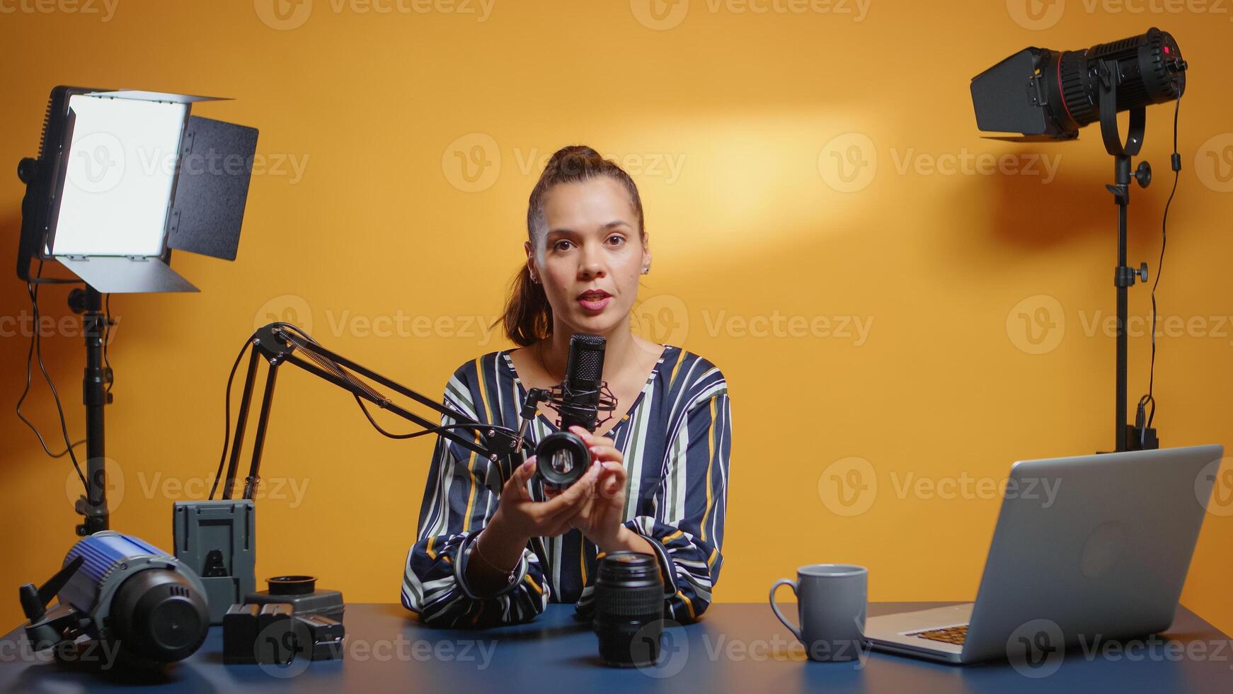 Social media star reviewing two camera lenses in her professional studio. Content creator new media influencer talking video photo equipment for online internet web show