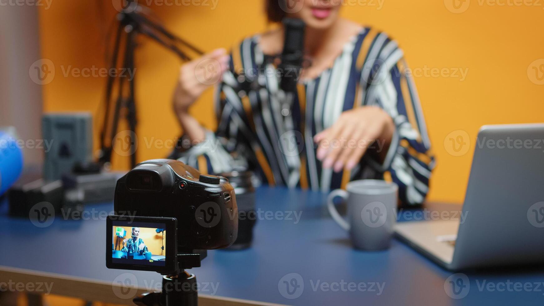 Content creator talking about camera lens in new podcast episode, selective focus on recording camera. new media star influencer on social media talking video photo equipment for online internet web show