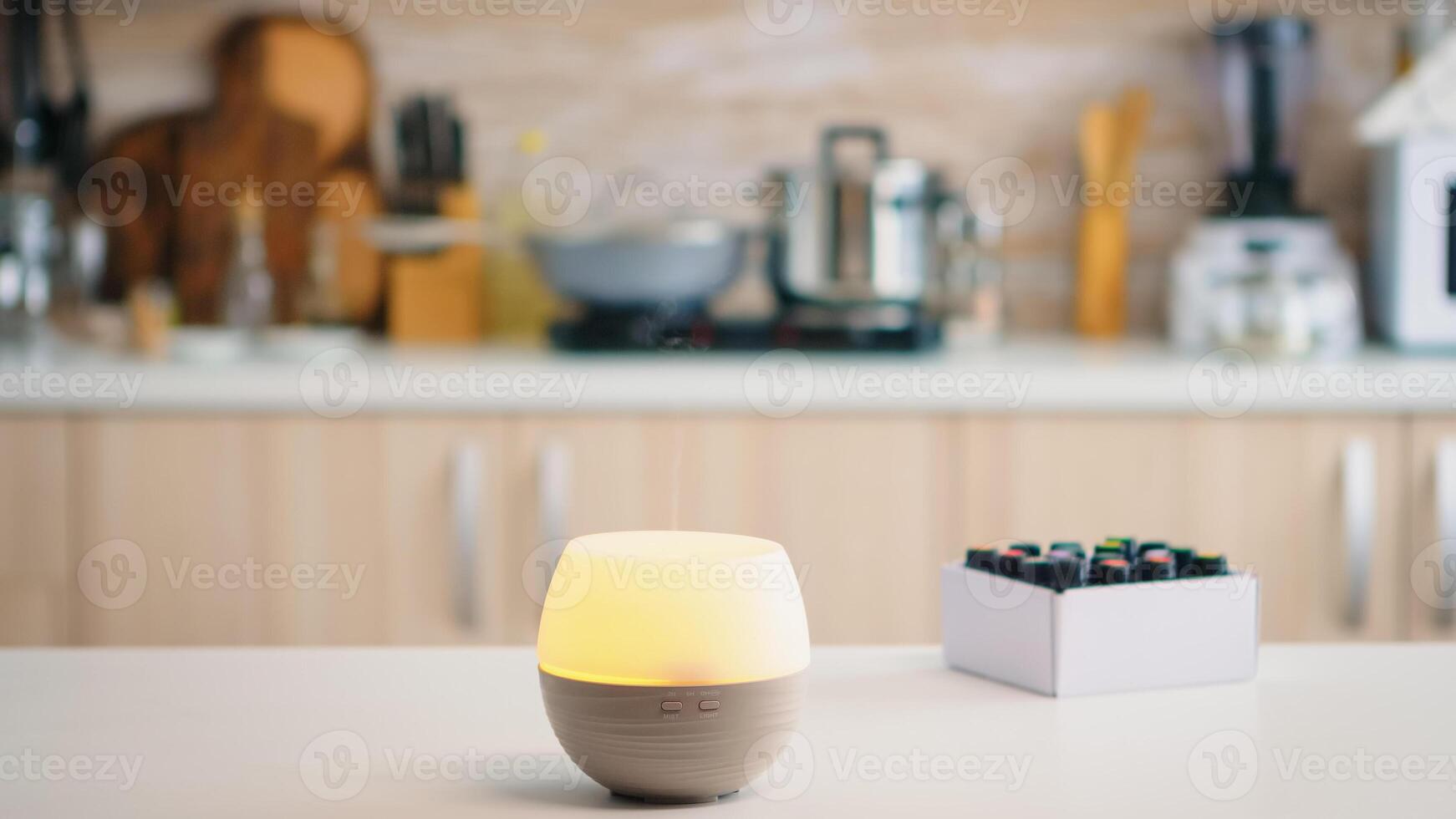 Wellness aromatherapy essential oils diffuser diffusing fragrance into the kitchen. Aroma health essence, welness aromatherapy home spa fragrance tranquil theraphy, therapeutic steam, mental health treatment photo