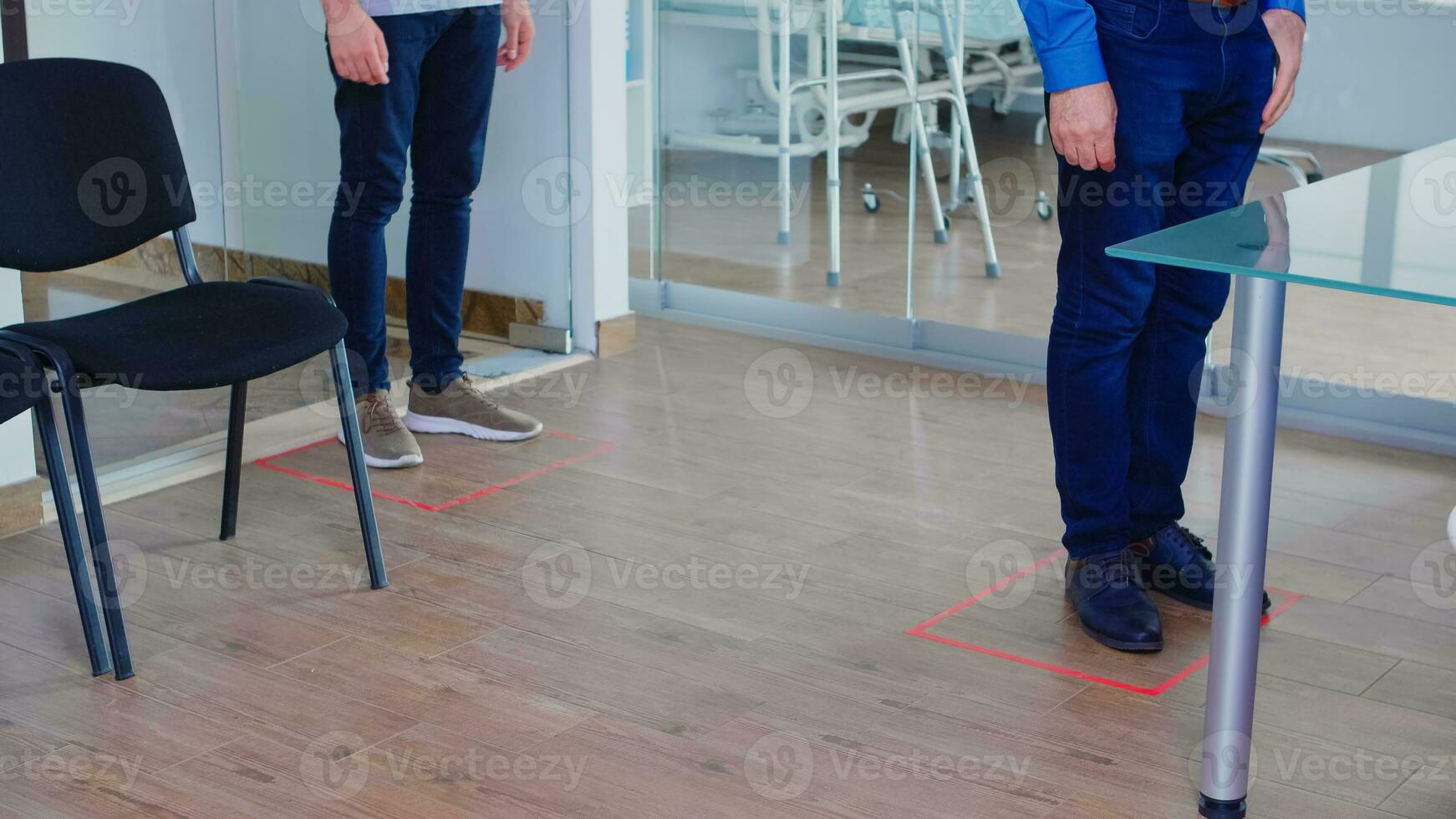 Patients during social distancing in hospital reception. Coronavirus sign in clinic waiting area. Global health care crisis pandemic, distance sticker photo