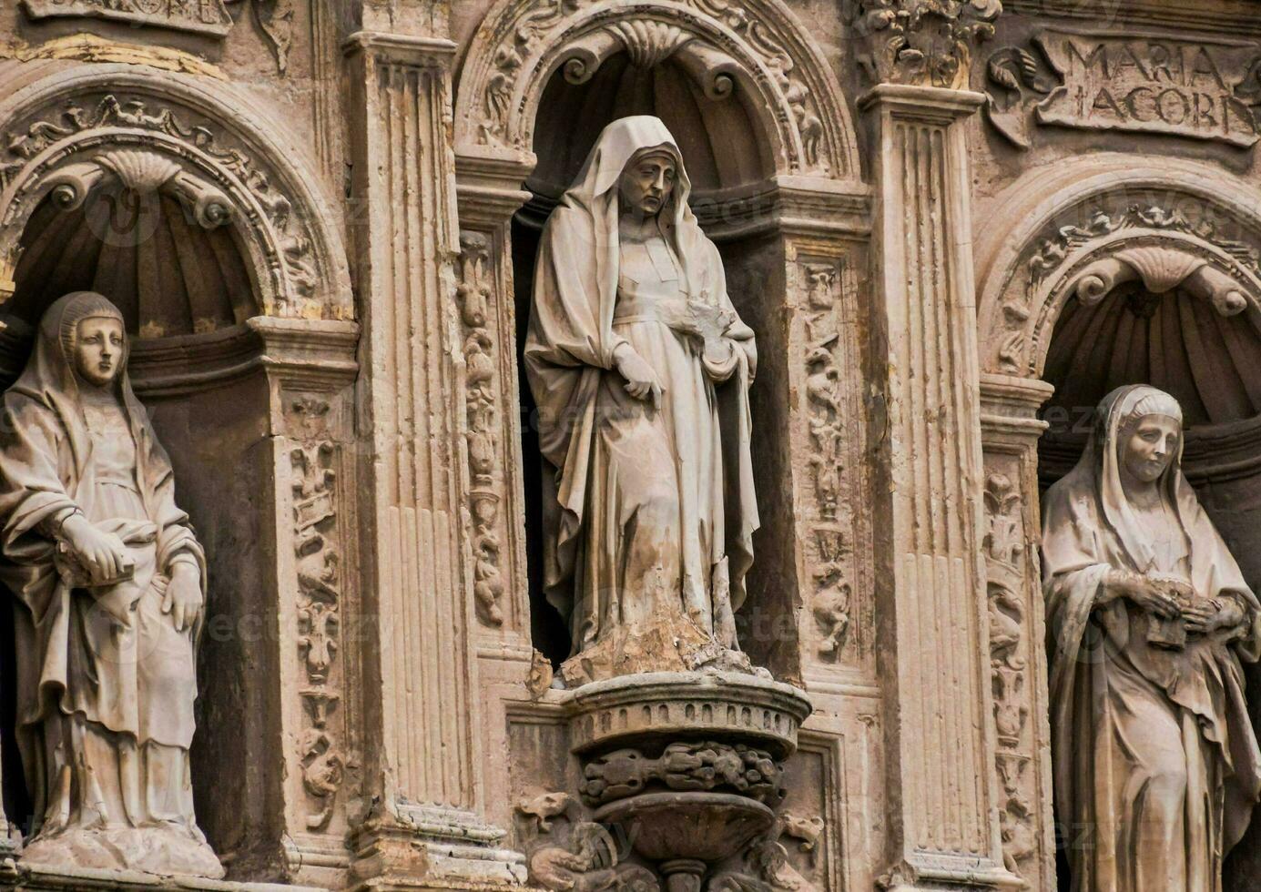 statues of the holy trinity on the facade of a building photo